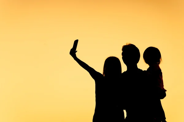 Famiglia facendo selfie silhouette — Foto Stock