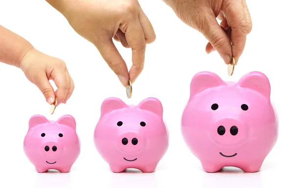 Golden coins to a pink piggy banks — Stock Photo, Image