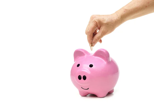 Mão colocando moeda em um banco porquinho — Fotografia de Stock