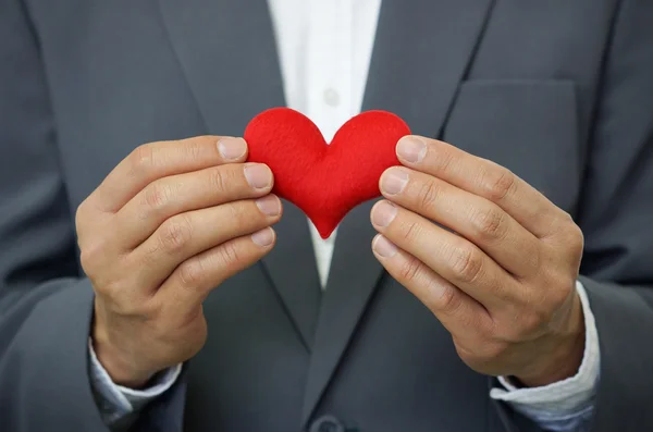 Un om de afaceri care ține o inimă roșie — Fotografie, imagine de stoc