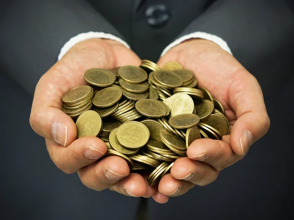 Manos de un hombre de negocios con monedas — Foto de Stock