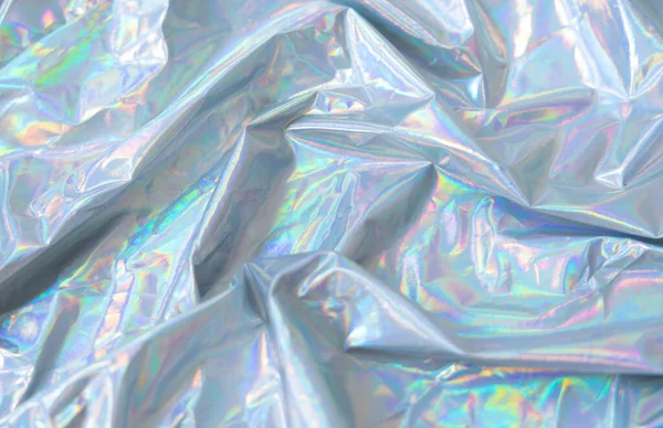 Holographic Y2K iridescent fabric background, Crumpled holographic fabric with iridescent glow in pastel tones. Trendy Y2K aesthetic background with dreamy metallic texture and soft light reflections