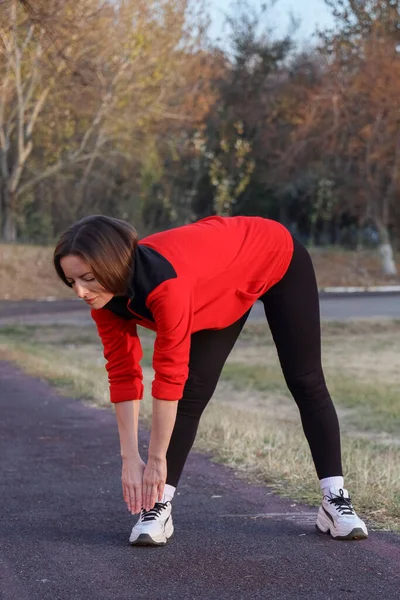 Dişi koşucu koşmadan önce ısınıyor ve öne eğiliyor..