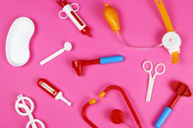 Pembe arka planda oyuncak tıbbi doktor araçları