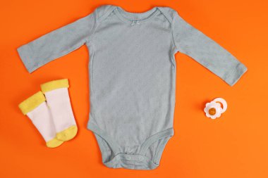 Yeni doğmuş bebek kıyafetleri ve parlak bir arka planda çoraplar.