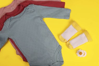 Yeni doğmuş bebek kıyafetleri ve parlak bir arka planda çoraplar.