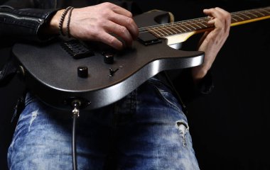 Gitarist penayla elektro gitar solosu çalıyor.