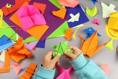 çocuk renkli kağıtlardan origami el sanatları yapıyor