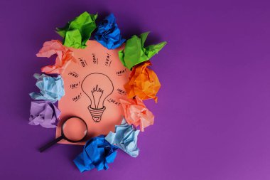 Yaratıcı başarılı fikir kavramı, buruşmuş kağıtların arasında bir ampul.