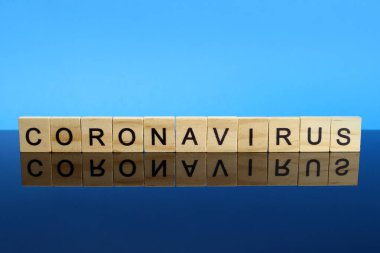 Coronavirus kelimesi ayna yüzeyindeki ahşap harflerden yapılmış. Covid-19 veya 2019-ncov virüsü kavramı.