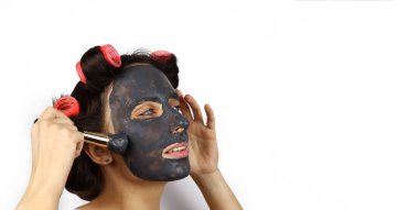 Yüzünde kozmetik maske olan güzel bir ev hanımı. Beyaz arkaplanda izole