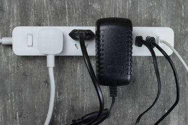 Gri arka planda birden fazla elektrik kablosu olan güç şeridi