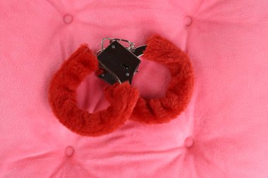 Yastığın üzerinde pembe tüylü kelepçeler. Sevgililer Günü