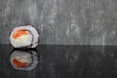 Ayna yüzeyinde taze, lezzetli suşi ruloları. Metin için boşluk