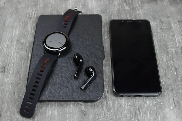 Gadgets-tablet, smartphone, smart watch, headphones on a gray table