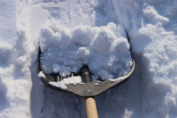 Clearing the road from snow with a shovel