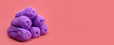 Pembe arka plandaki bir piramidin içindeki yün ipliklerin derileri. Yatay pankart. Metin için alanı kopyala