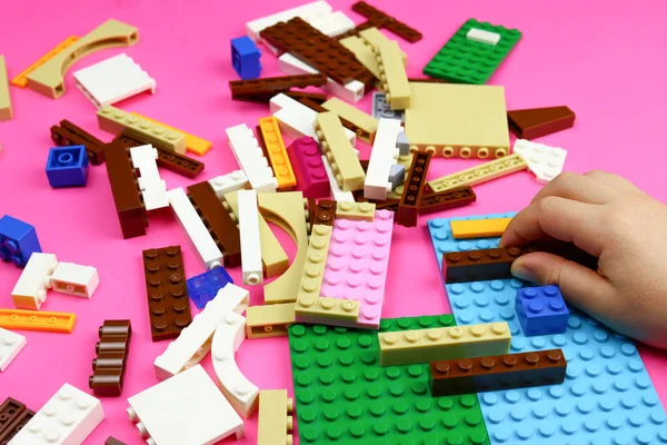 小孩在粉红的桌子上玩彩色玩具块 有选择的重点 — 图库照片