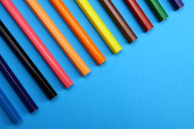 mavi arkaplanda renkli kalemler yakın plan