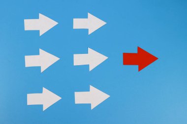 Beyazlar grubuna öncülük eden bir kırmızı kağıt ok. Liderlik kavramı