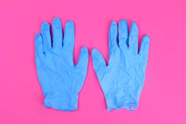 Pembe arka planda ödev için lastik eldivenler