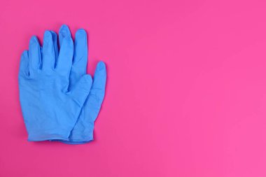 Pembe arka planda ödev için lastik eldivenler. Metin için alanı kopyala