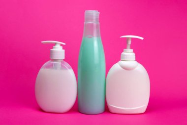 Şampuan ve sıvı sabun pembe arka planda bir şeker kutusuyla şişede.