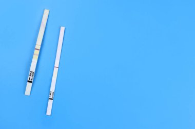 Mavi arka planda pozitif ve negatif gebelik testi