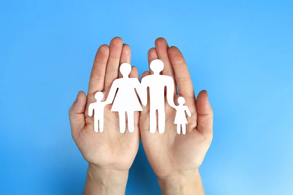 Paper family in hand on a blue background