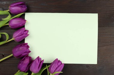 Ahşap arka planda bir buket lale olan tebrik kartı, maket. Metin için alanı kopyala