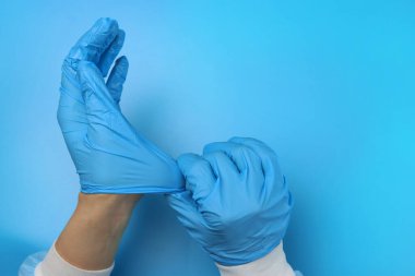 Doktor ya da hemşire ellerine lateks eldiven takıyor.