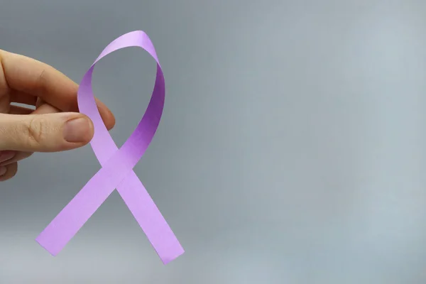 purple ribbon in hand, Symbol of Epilepsy, Alzheimer's disease, Pancreatic cancer, Thyroid cancer