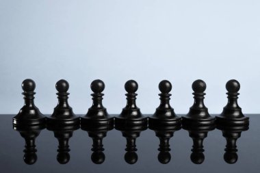 Sıra, sıra, bir grup siyah satranç piyonu. Liderlik kavramı. Siyah ve beyaz
