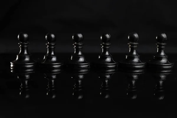 line, a row, a crowd of black chess pieces of pawns. Leadership concept
