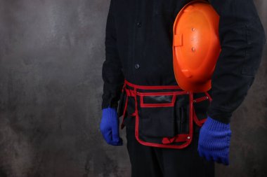 Özel üniformalı bir işçi koruyucu bir miğfer taşıyor.