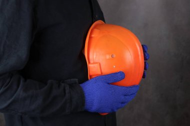 Özel üniformalı bir işçi koruyucu bir miğfer taşıyor.