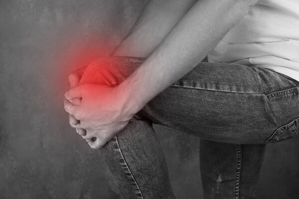 man having trouble with knee, red area of pain