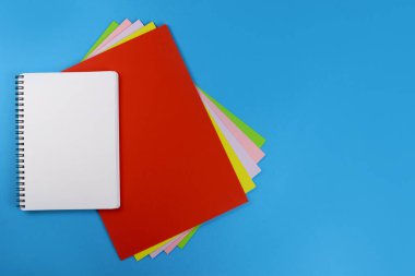 Renkli kağıtların üzerindeki boş not defteri sayfası