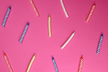 Pembe arka planda renkli doğum günü mumları. Kutlama partisi. Arkaplan, doku