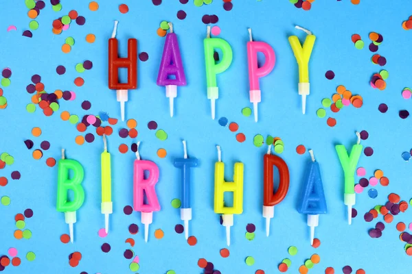 Colorful happy birthday candles on a blue background