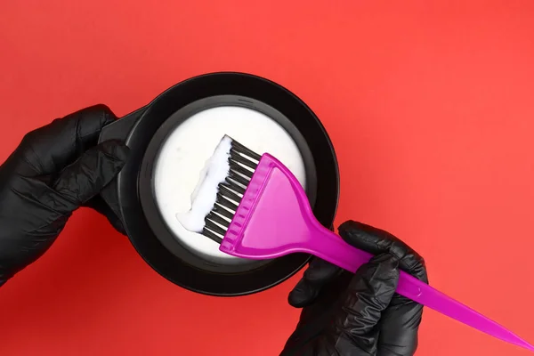 Estilista Sostiene Tazón Tinte Para Cabello Sobre Fondo Rojo — Foto de Stock