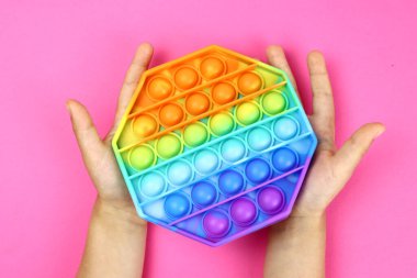 Renkli poppit oyunu olan çocuk, popüler bir anti-stres oyunu
