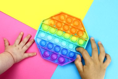 Renkli poppit oyunu olan çocuk, popüler bir anti-stres oyunu