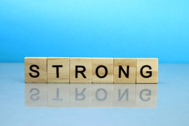 Mavi arka planda tahta bloklardan yapılmış güçlü bir sözcük