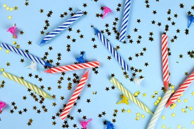 Mavi arka planda renkli mumları ve parlak yıldızları olan doğum günü arkaplanı. Şenlikli maket.