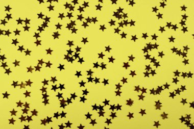 Sarı arka planda parlak yıldızlı konfeti, bayram, doğum günü