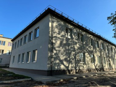 Güneş ışığı ve ağaç gölgeleriyle çok katlı bina bir model oluşturuyor.