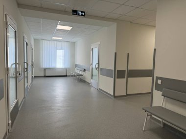 Bankları ve penceresi olan temiz, modern hastane koridoru.