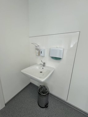 Modern bir sağlık ortamında beyaz lavabo ve hijyen malzemeleri