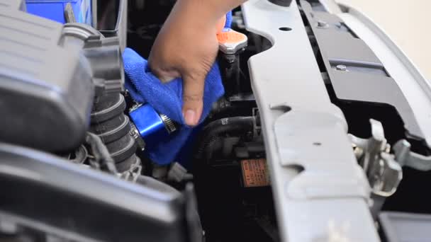 Main de l'homme en utilisant un tissu de micro fibre bleue pour nettoyer la voiture  - — Video